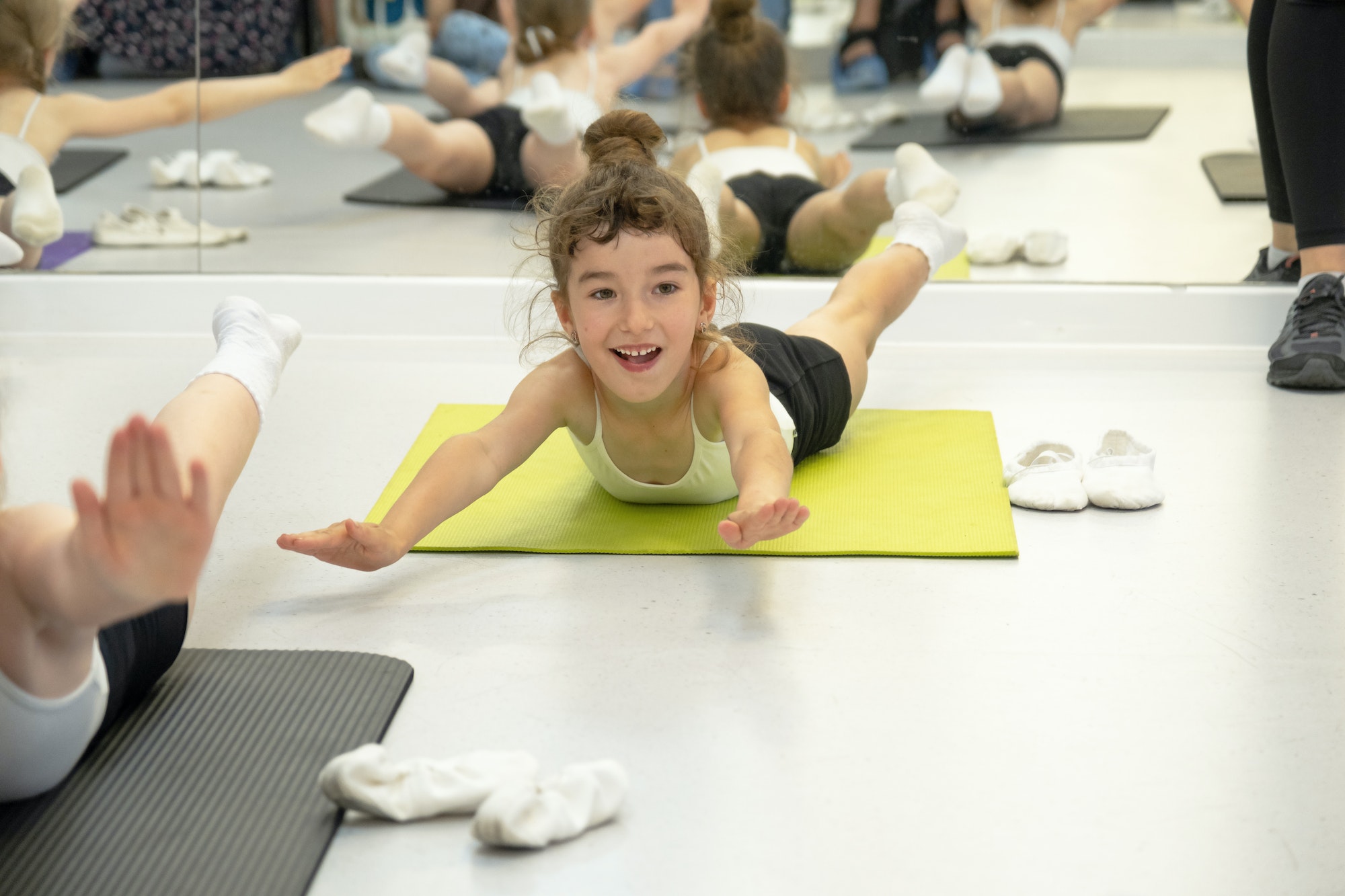 Child trains in gym on the mat, does stretching exercises and abs, gymnastics